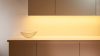 Una escena de sala de estar acogedora con iluminación de tira LED colocada detrás de un televisor, proporcionando una luz de fondo ambiental suave que realza la atmósfera de la habitación.