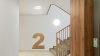 Escalera interior bien iluminada con luces LED, garantizando seguridad y visibilidad, en cumplimiento con la normativa UNE-EN 12464-1