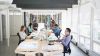 Oficina moderna con empleados trabajando, iluminada adecuadamente con luces LED que cumplen la normativa UNE-EN 12464-1 para un ambiente de trabajo confortable y seguro